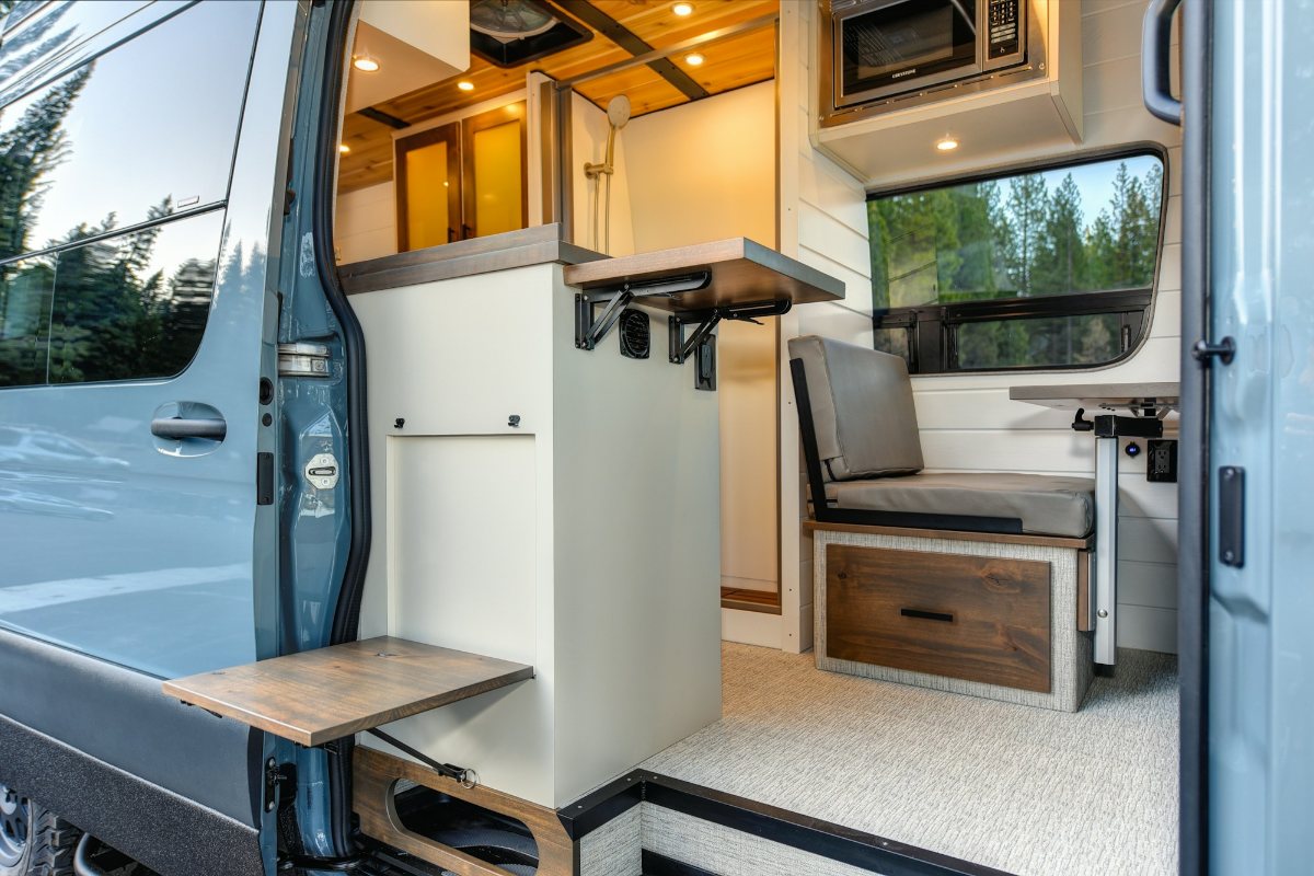 RV storage ideas: camper van interior with a fold-down table, bench seat and built-in drawers