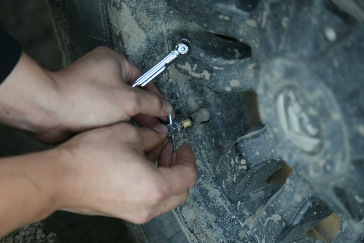 RV maintenance checklist: checking tire pressure with a gauge on the valve stem