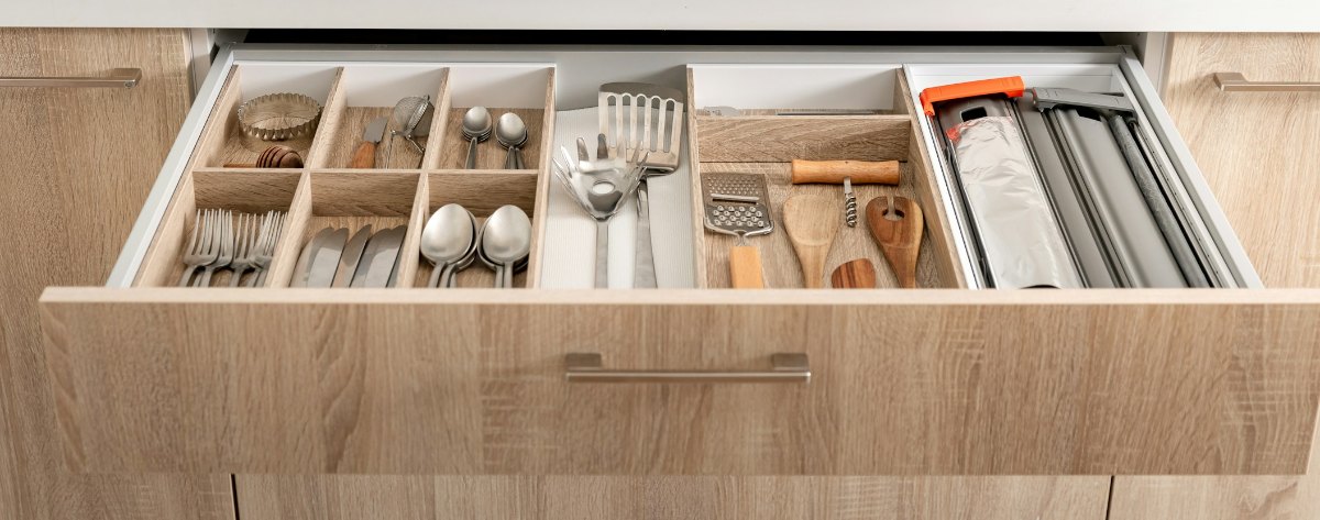 Close-up of an open kitchen drawer with dividers keeping cutlery and utensils in place