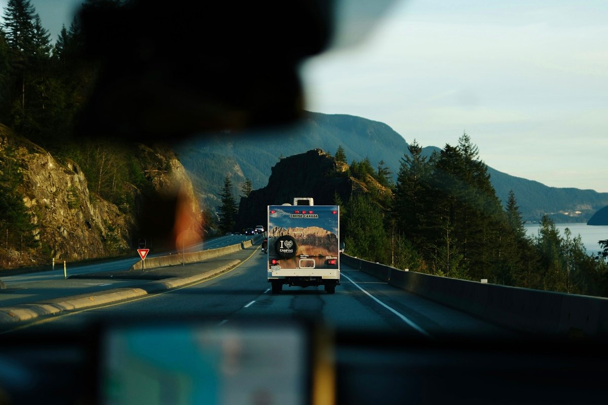 An RV driving on a mountain highway, seen from the vehicle following at a safe distance